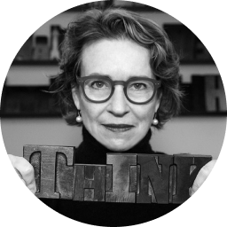 Gloria Kondrup in black and white holding on wood block type that is spelling out the word 'THINK'